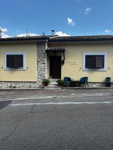 a building with two chairs and a table in front of it at La Casetta di Mary sulla Via dei Tusci in Castiglione in Teverina