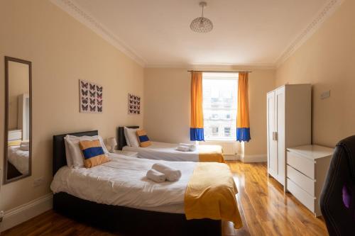 a bedroom with two beds and a window at 3 Bedroom Apartment with castle views in Edinburgh
