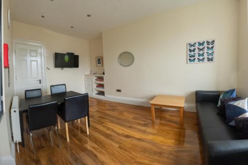 a living room with a table and a couch at 3 Bedroom Apartment with castle views in Edinburgh