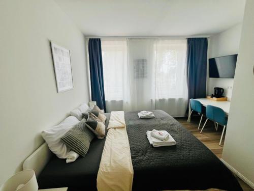 a bedroom with a bed with two towels on it at Mythos Hotel Oranienburg in Oranienburg