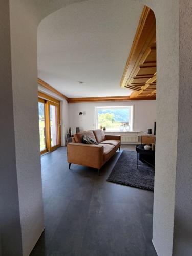 a living room with a couch and a large window at atHOME Appartements in Rattendorf