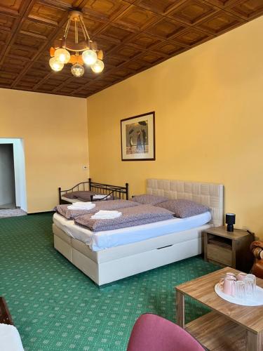 a bedroom with two beds and a table at ART hotel MAXIM in Frýdek-Místek