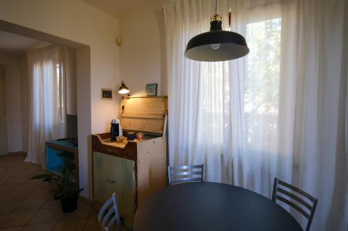 a kitchen and dining room with a table and a window at Tenuta Lo Scricciolo in Orentano