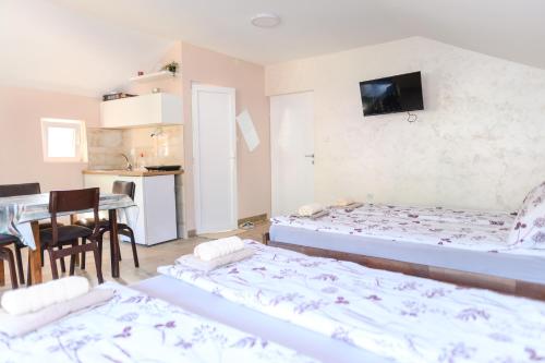 a room with two beds and a kitchen with a table at Vila Misljenovic, u centru Sokobanje, na pesackoj zoni in Soko Banja