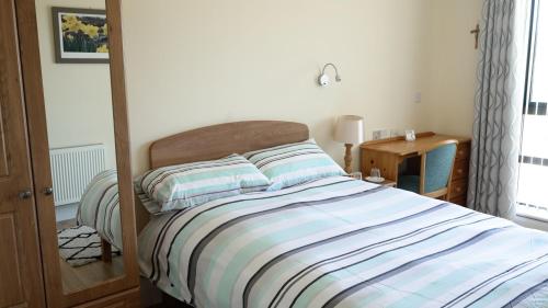 a bedroom with a bed and a table with a lamp at Father Peyton Centre, Ballina 
