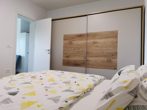 a bedroom with a bed with a large headboard at Apartma Lipa in Veliki Gaber