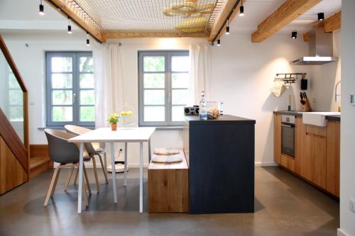 una cucina con un tavolo e una sala da pranzo di Westertilli Eckhuus - modernes, luxuriöses Wohngefühl a Pellworm