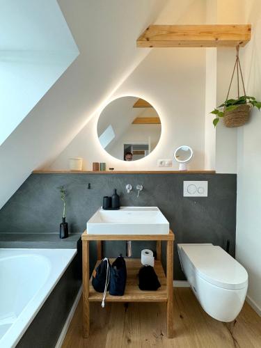 a bathroom with a sink and a toilet and a tub at Westertilli Eckhuus - modernes, luxuriöses Wohngefühl in Pellworm