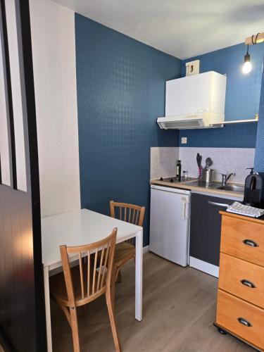 une petite cuisine avec une table et des chaises blanches dans l'établissement Studio AXEL entre plage et port de plaisance, à La Rochelle