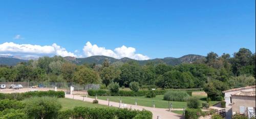 a view of a park with mountains in the background at Hotel Olmuccio in Sainte-Lucie de Porto-Vecchio