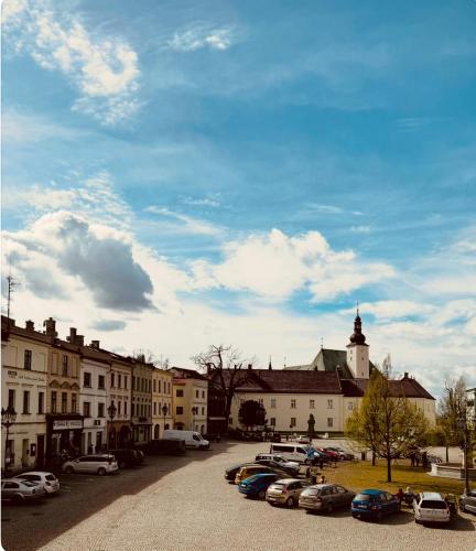 a parking lot with cars parked in front of buildings at ART hotel MAXIM in Frýdek-Místek