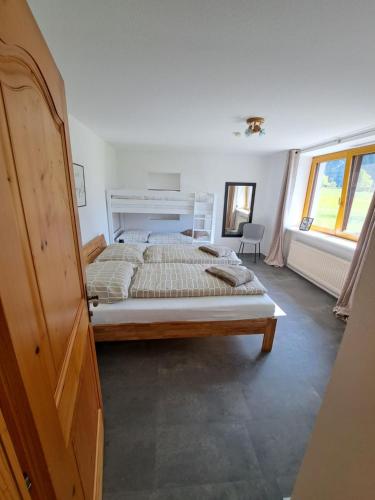 a bedroom with a bed and a large window at atHOME Appartements in Rattendorf