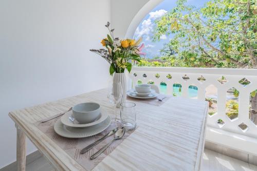 a table with a vase of flowers on a table at Hibiscus in Diani Beach