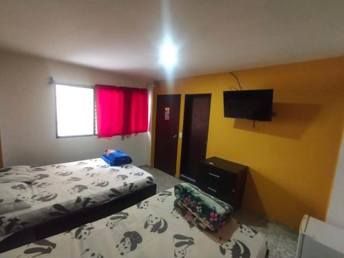 a bedroom with a bed and a flat screen tv at Hotel ZONA ROSA MARINILLA in Marinilla