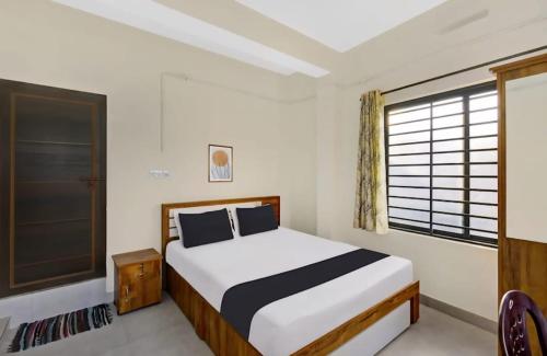 a bedroom with a bed and a window at Hamai Grand Home Stay in Ambalavayal
