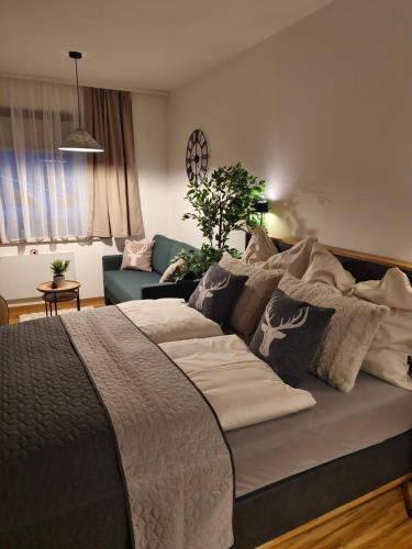1 dormitorio con cama con almohadas y sofá en Forest Apartment Gosau, en Gosau
