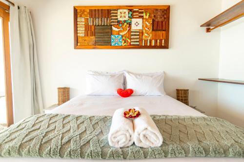 a bedroom with a bed with towels on it at Pousada Aroeira in Morro de São Paulo