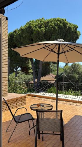 a table and two chairs and an umbrella on a patio at HeidiHouse in Patra