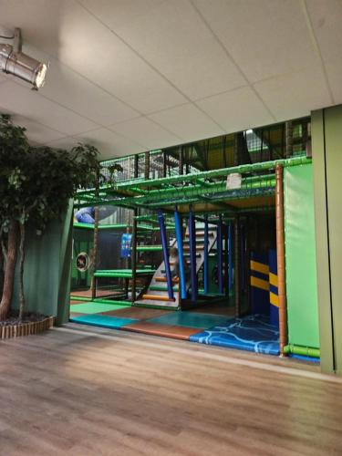 a room with a play area with a playground at Knus boomstamhuisje op de Schatberg - nabij Toverland in Sevenum