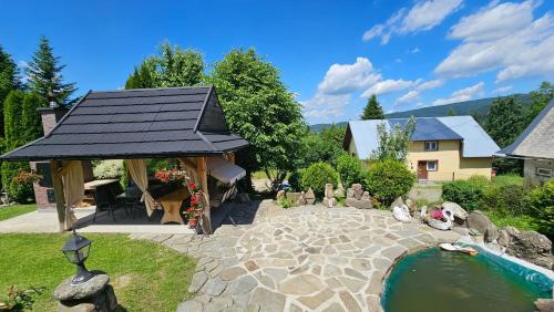 a garden with a gazebo and a pond at Agroturystyka na szlaku in Lubomierz