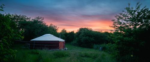 a red barn with a white tent in a field at MoonYurt in Gannat