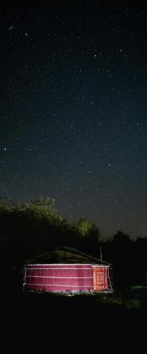 a red building under a starry sky at night at MoonYurt in Gannat