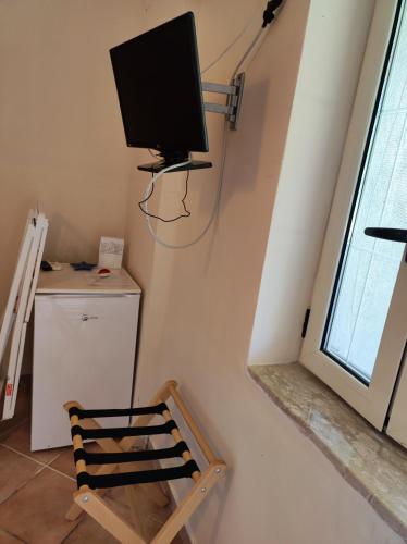 a room with a chair and a tv on the wall at IL CONTE DI MARRAONE in Agnone