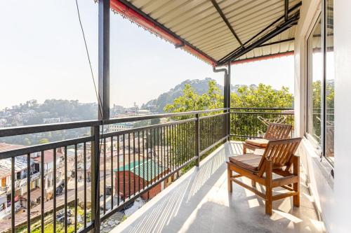 d'un balcon avec deux chaises et une vue. dans l'établissement Trim Cottage By Lehriyat Retreats, à Mussoorie