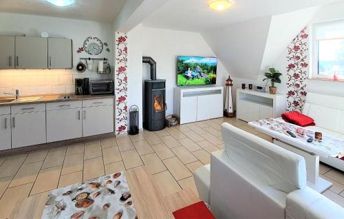 a kitchen and living room with a couch and a tv at Ferienwohnung Nepperminusedom in Neppermin