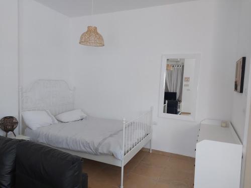 a white bedroom with a bed and a mirror at בוטיק גלילי - Galilee Boutique in Kefar Blum