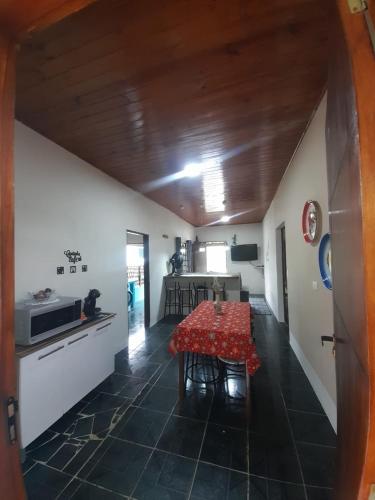 a dining room with a table and a kitchen at Casa Aconchegante na Roça - São Francisco Xavier in São Francisco Xavier
