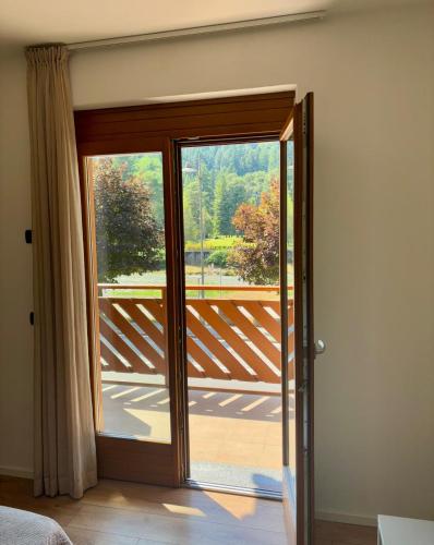 a room with a sliding glass door to a balcony at Terrazza sul Parco in Comano Terme