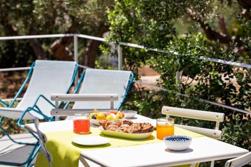 a table with a plate of food and two chairs at Casale la Macina Residence Scopello in Scopello