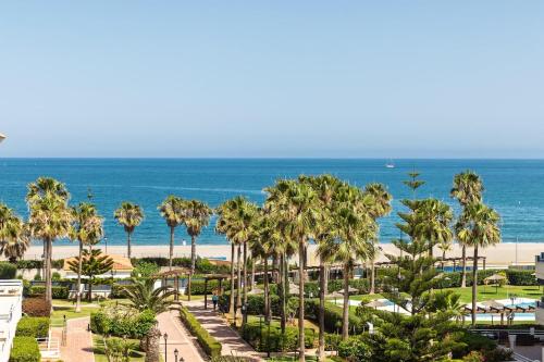 a view of a beach with palm trees and the ocean at La Noria de Julie in San Luis de Sabinillas
