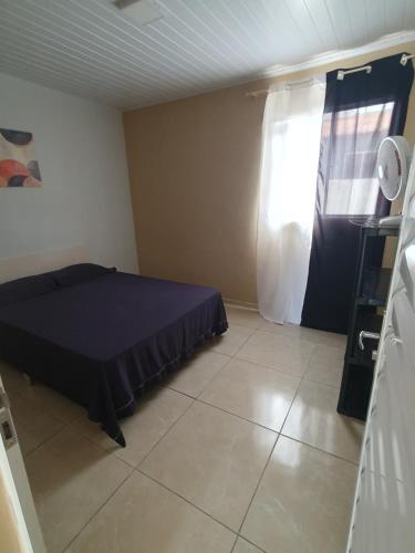 a small bedroom with a bed and a window at Casa de locação in Goiana
