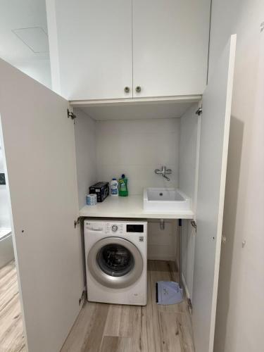 a laundry room with a washing machine and a sink at Ines Apartments in Giardini Naxos