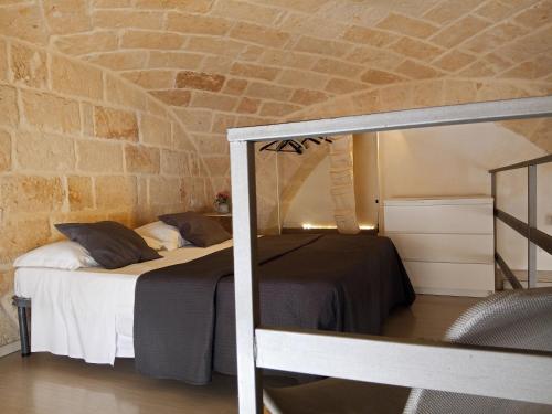 a bedroom with a bed and a brick wall at Monolocale prezioso in Trani