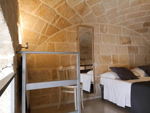 a room with a bed and a mirror in a stone wall at Monolocale prezioso in Trani