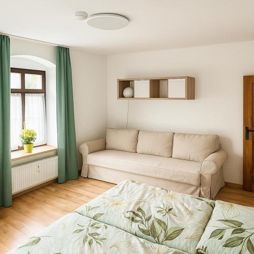 a living room with a couch and a window at Ferienwohnung auf der Schlossallee in Niederwiesa