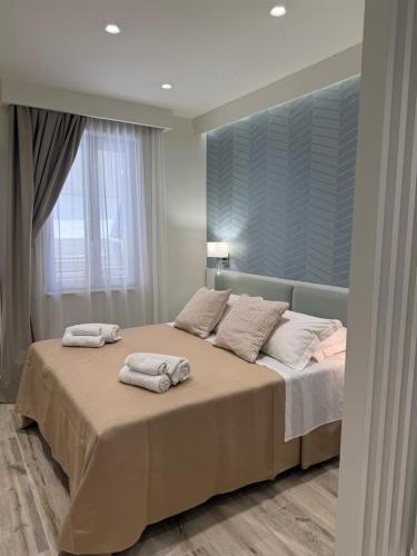a bedroom with a large bed with towels on it at Ines Apartments in Giardini Naxos