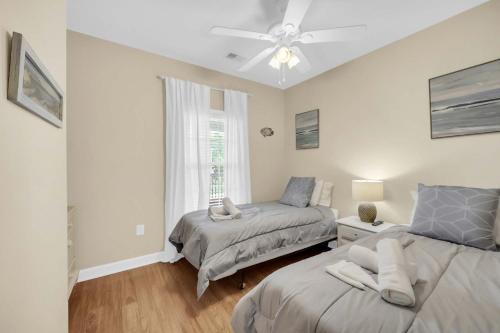 a bedroom with two beds and a ceiling fan at Sandy Tee Resort Suite w Giant Pool Oasis in Myrtle Beach