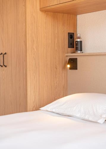 a bedroom with a white bed with a speaker on the wall at Emeraude, appartement vue mer in La Croix-Valmer