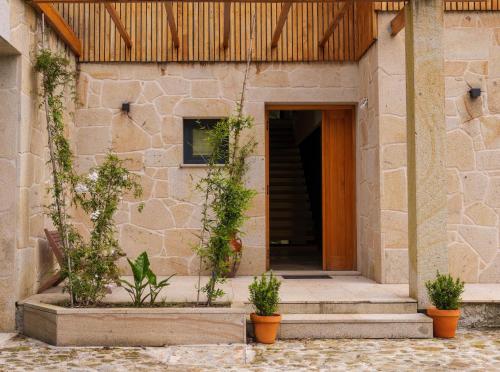 a building with a door and some potted plants at Quinta da Fenteira - Casa Lima in São Jorge