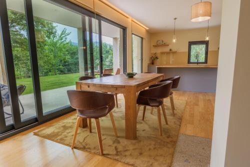 a kitchen and dining room with a wooden table and chairs at Quinta da Fenteira - Casa Lima in São Jorge