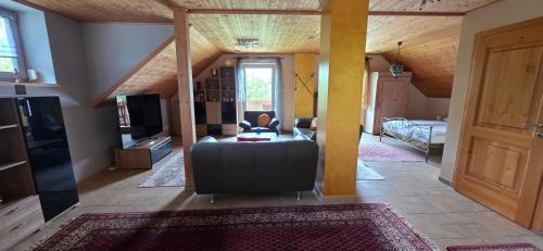 a living room with a couch and a television at Haus Sonnhof in Herzogau