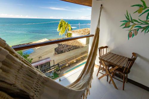 a hammock in a room with a view of the ocean at Pousada Aroeira in Morro de São Paulo
