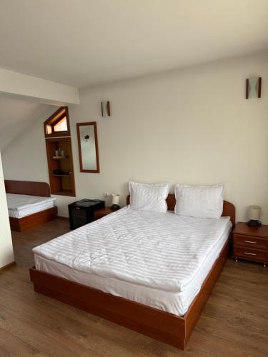 a bedroom with a large bed with white sheets and pillows at SPA Hotel Daffi in Smolyan