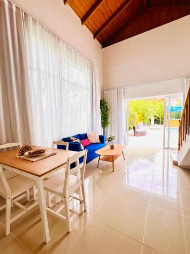 a living room with a table and a blue couch at Cabaña en punta cana in Punta Cana