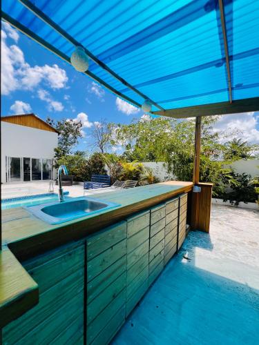 a kitchen with a counter top with a blue roof at Cabaña en punta cana in Punta Cana