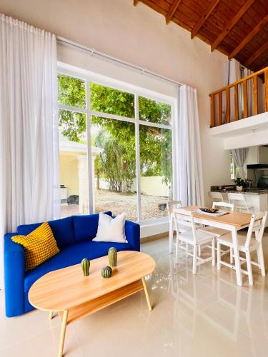 a living room with a blue couch and a table at Cabaña en punta cana in Punta Cana